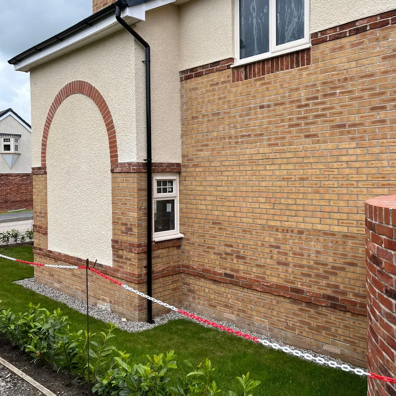 Brick arch and contrasting brick bands on the side of a new home.