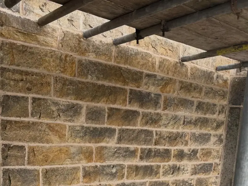 Close view of a sandstone wall with fresh, light-coloured mortar joints.