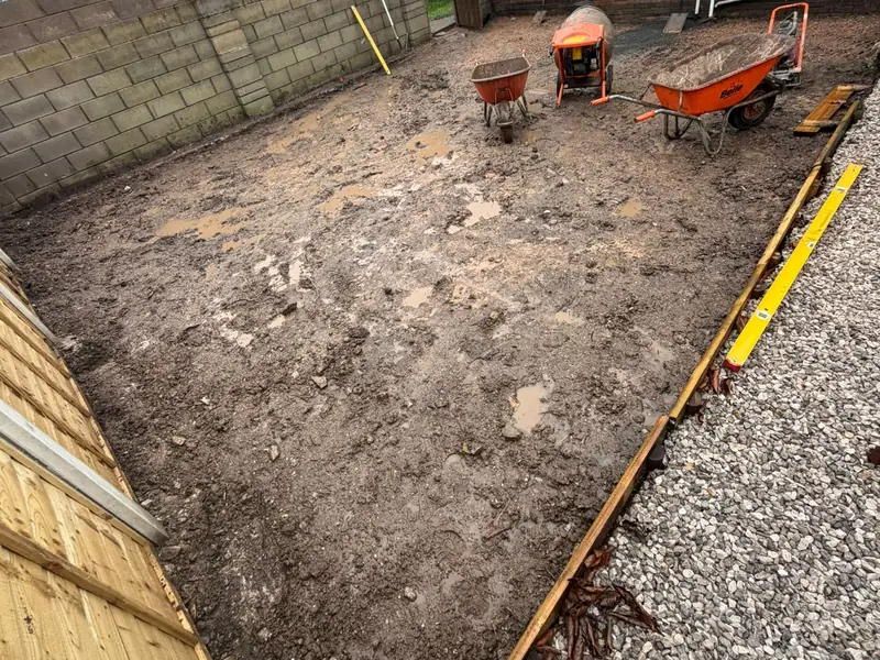 Rear garden excavated and levelled, with timber edging boards set along the gravel border.