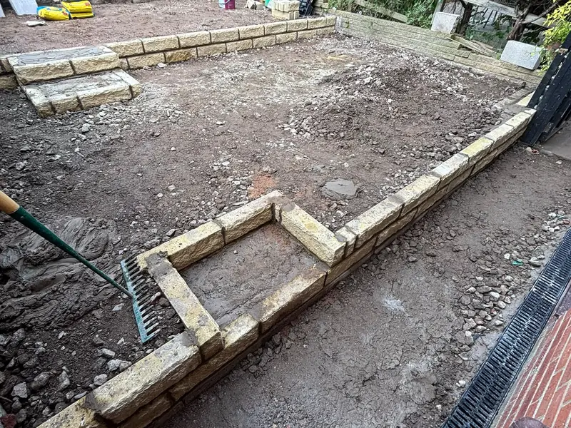 Garden cleared and excavated, with new stone walling forming two levels.