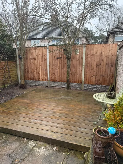 The same fence seen from the patio, with garden furniture in the foreground.