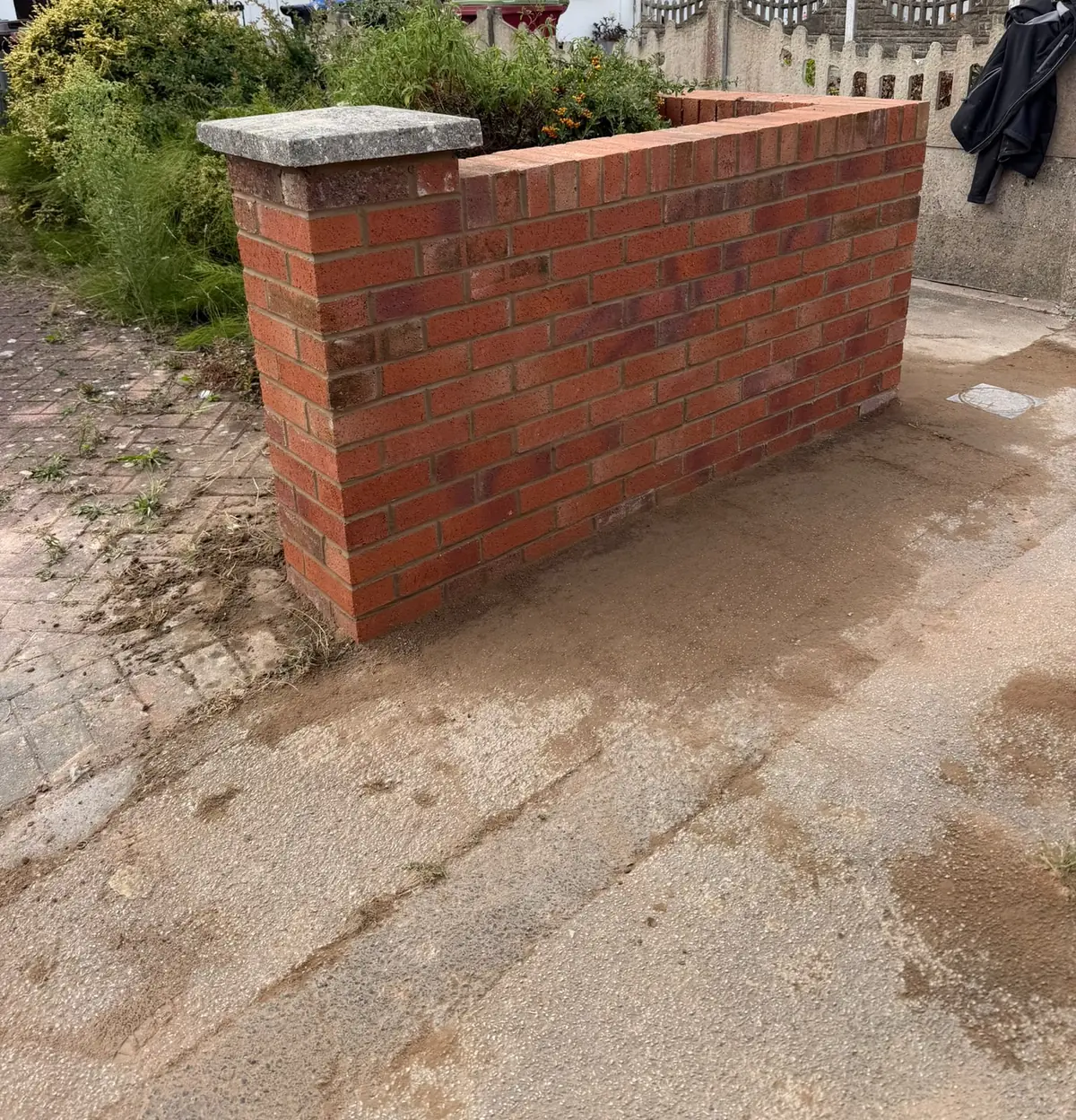 A finished red brick front garden wall and pier.