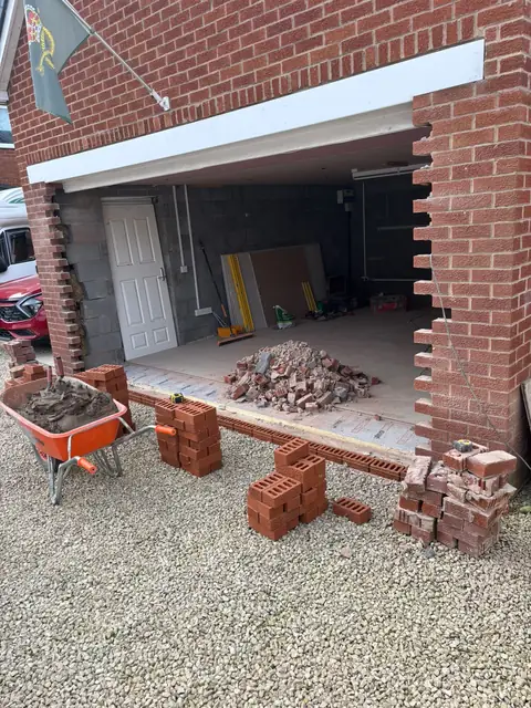Garage with its door removed and the brickwork either side cut back ready for new brickwork.