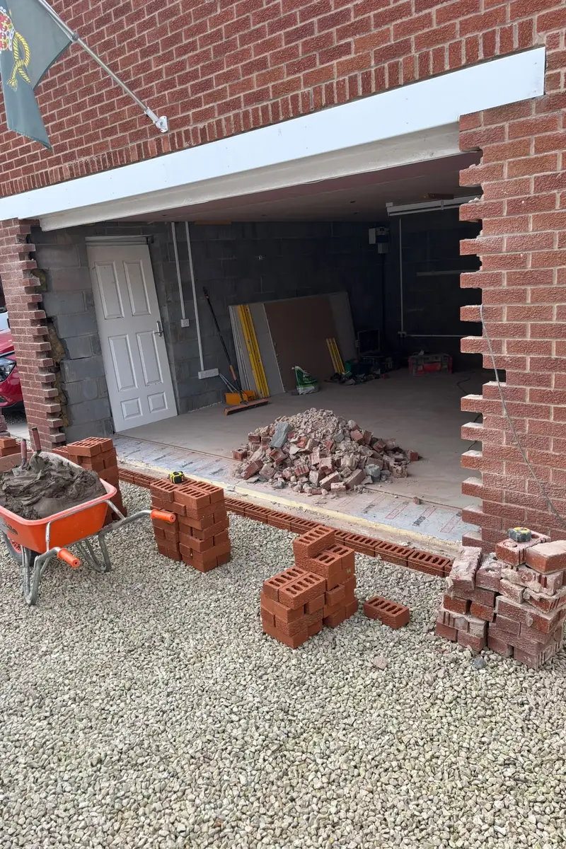 Garage with its door removed and the brickwork either side cut back ready for new brickwork.