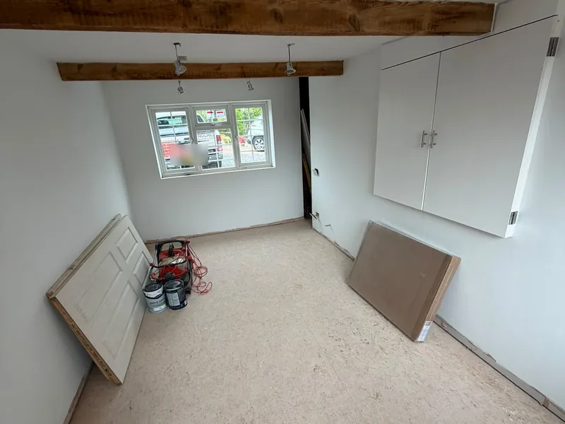The converted garage with walls painted white, before the floor covering was laid.